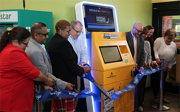 Photo of individuals cutting a ribbon in front of the SC DMV Express kiosk.
